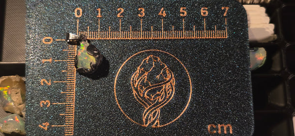 Raw uncut Ethiopian Welo opal pendant. Colour: multicolour, strong. Body: bluish. Placed next to a steel ruler for scale.