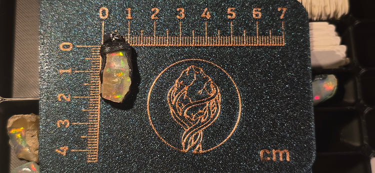 Raw uncut Ethiopian Welo opal pendant. Colour: multicolour, vivid. Body: light, deeper than usual. Placed next to a steel ruler for scale.