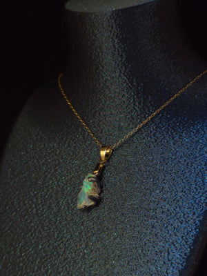 Raw uncut Ethiopian Welo opal pendant. Colour: blue and green, strong. Body: deep blue. Worn on a black display bust.