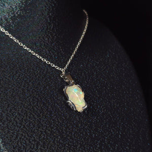 Raw uncut Ethiopian Welo opal pendant. Colour: green, moderate, comes and goes. Body: crystal clear. Worn on a black display bust.