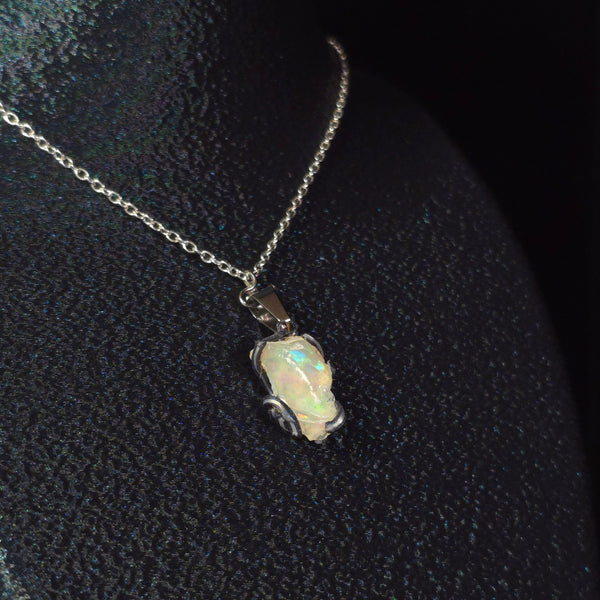 Raw uncut Ethiopian Welo opal pendant. Colour: green, moderate, comes and goes. Body: crystal clear. Worn on a black display bust.