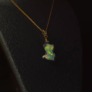 Raw uncut Ethiopian Welo opal pendant, every colour at once, blue body. Worn on a black display bust.