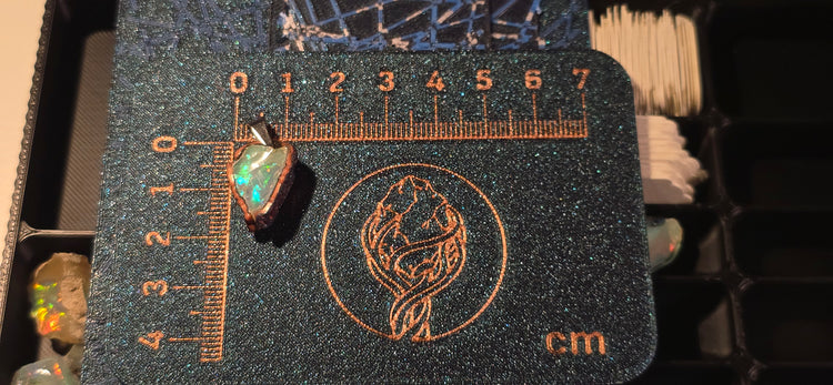 Raw uncut Ethiopian Welo opal pendant. Colour: blue, green, yellow, red, full spectrum, vivid. Body: clear. Placed next to a steel ruler for scale.