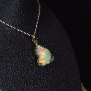 Raw uncut Ethiopian Welo opal pendant. Colour: full spectrum rainbow, moderate. Body: white. Worn on a black display bust.