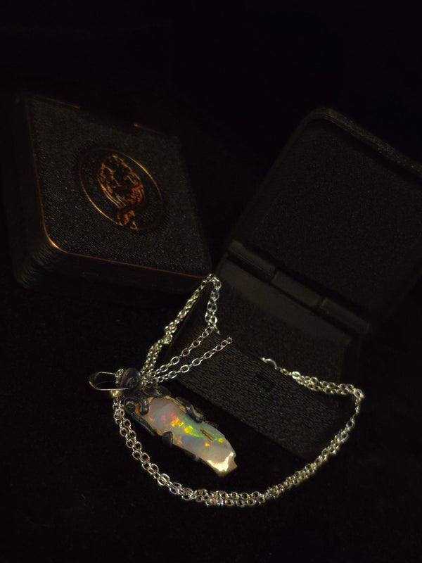 Raw uncut Ethiopian Welo opal pendant, rainbow flashes & red fire. Shown with its open gift box.
