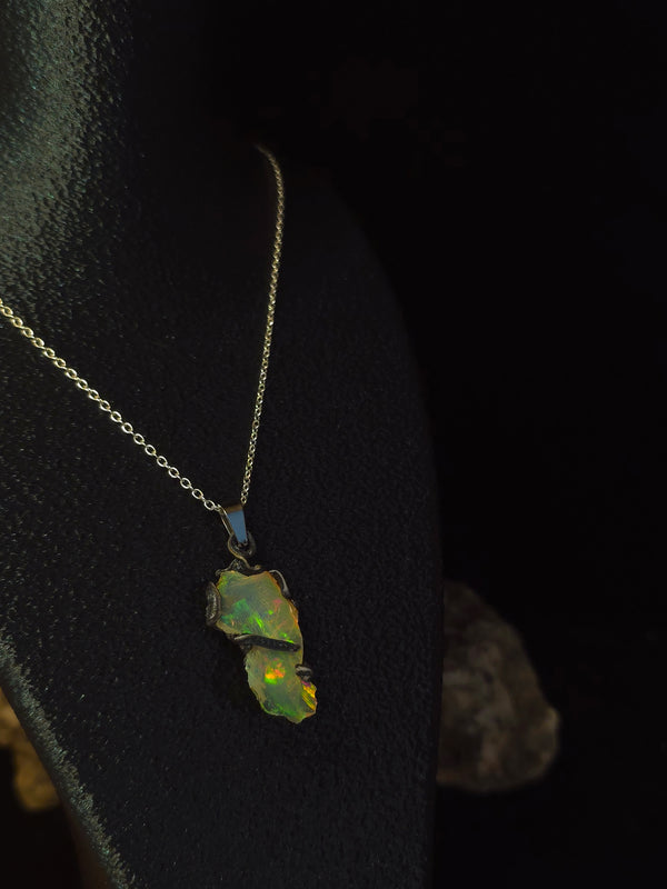 Raw uncut Ethiopian Welo opal pendant, shifting rainbow fire. Worn on a black display bust.